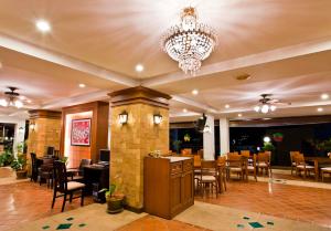 Jiraporn Hill Resort في شاطيء باتونغ: مطعم فيه ثريا وطاولات وكراسي