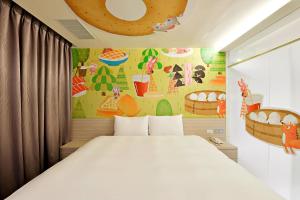 a bedroom with a bed and a wall with a painting at Whoops Hotel in Taichung