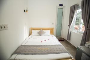 a small bedroom with a bed with white sheets at Shark Homestay in Hue