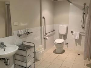 a white bathroom with a toilet and a sink at Quest Chermside in Brisbane