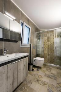 a bathroom with a sink and a toilet at Villa Emerald with swimming pool in Lindos in Líndos +14 photos
