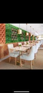 a long dining room with white tables and white chairs at Quest St Leonards in Sydney