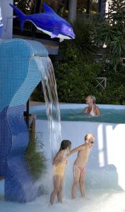 リド・ディ・カマイオーレにあるHotel Eurの滝のあるスイミングプールで遊ぶ子供2名