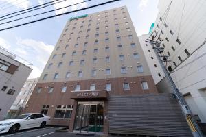 un edificio con un coche blanco aparcado delante de él en Hotel Econo Tsu Station, en Tsu