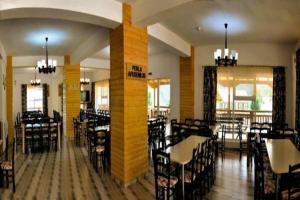 une salle à manger avec des tables et des chaises dans un restaurant dans l'établissement Perla Apusenilor, à Albac