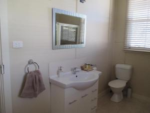a bathroom with a sink and a toilet and a mirror at Maeville Cottage in Broken Hill +23 photos