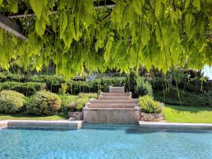 a fountain in a garden under a tree with green leaves at Wild Agriturismo Podere della Bruciata in Chiusi