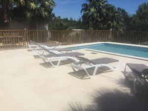 een groep ligstoelen naast een zwembad bij le verso in Narbonne