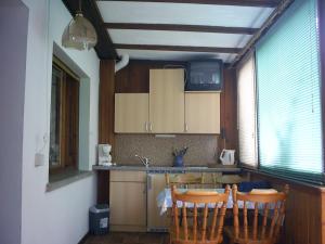 eine Küche mit einem Tisch und 3 Stühlen in der Unterkunft Ferienhaus Krähmer in Kelbra