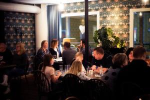 un grupo de personas sentadas en una mesa en un restaurante en Lilla Hotellet, en Vilhelmina