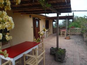 PianellaにあるAgriturismo Via del Campoの赤いテーブルと椅子が備わる家のパティオ