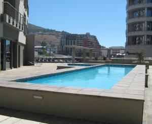a large blue swimming pool in a building at Luxury Apartments at the Icon, Walking distance to CTICC in Cape Town in Cape Town