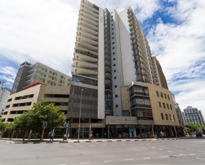 a large building on a street in a city at Luxury Apartments at the Icon, Walking distance to CTICC in Cape Town in Cape Town