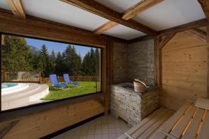 ein Zimmer mit einem großen Fenster in einem Holzhaus in der Unterkunft Hotel Gran Mugon in Vigo di Fassa