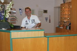 a man standing behind a counter in a store at Hotel Alte Viehweide in Helferskirchen