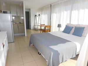 een slaapkamer met een groot bed met blauwe kussens bij studio 38 climatisé balcon vue mer in Le Grau-du-Roi +6 foto's