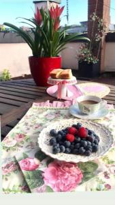 a table with a plate of berries and a cup of coffee at B&B Independente in Assago