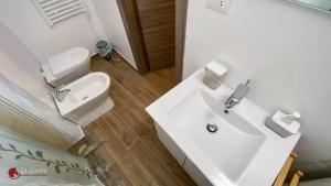 een badkamer met een witte wastafel en een toilet bij CASA VACANZE LA GIOSTRA in Lettomanoppello