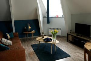 a living room with a couch and a tv at Residence Monsigny in Boulogne-sur-Mer