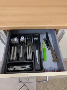 un tiroir rempli d'ustensiles dans une armoire dans l'établissement Apartma Piran, à Piran