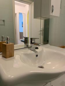 un lavabo blanc dans une salle de bain avec un miroir dans l'établissement Apartma Piran, à Piran