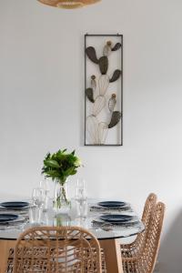 a dining room table with chairs and a picture on the wall at Cap à l'Ouest by Cocoonr in Saint Malo