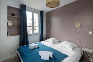 a bedroom with two towels on a bed with a window at Cap à l'Ouest by Cocoonr in Saint Malo
