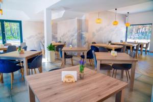 restauracja z drewnianymi stołami i krzesłami w pokoju w obiekcie Plaża Resort w Łebie