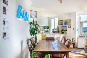 a kitchen and dining room with a wooden table and chairs at Oh My Beach View - Top Floor Paradise by Sydney Dreams Serviced Apartment Bondi in Sydney