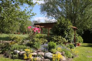 a garden with a gazebo and flowers at Landhaus Dreesen in Timmendorfer Strand