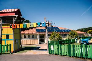 a house with a green fence and a building with solar panels at Lisebergsbyns B&B in Gothenburg