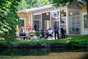 a group of people sitting around a table on the porch of a house at Lisebergsbyns B&B in Gothenburg