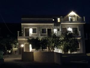 uma casa branca com uma varanda à noite em TA DIDYMAKIA APARTMENTS. em Argostoli