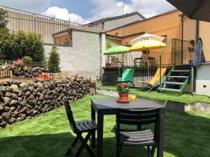 a table with two chairs and an umbrella in a yard at Etna Vintage in Linguaglossa