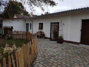 a white house with a fence and a brick driveway at Apartment am Birkenfeld Allgäu Kaufbeuren in Steinholz