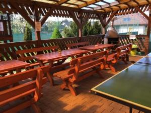 a group of wooden tables and benches in a pavilion at Guest House Maxim in Liptovský Mikuláš