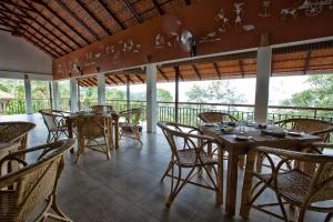 Meppādi的住宿－After the Rains - Rainforest Lodge，阳台餐厅,配有桌椅