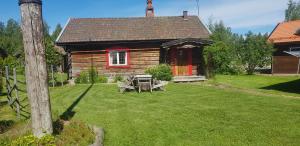 a house with a picnic table in front of it at Mora Life, Åmåsängsgården in Mora