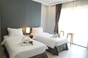 2 Betten in einem Hotelzimmer mit Blumen darauf in der Unterkunft Fide Hotel in Ho-Chi-Minh-Stadt