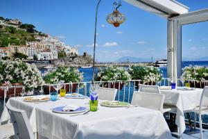 a restaurant with tables and chairs with a view of the water at Casa Amore S Lucia in Amalfi