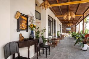 a hallway with chairs and a table and a table and chairs at The Boathouse Riverside Homestay in Hoi An