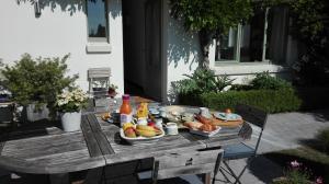 a picnic table with food and drinks on it at little cottage in Lasne