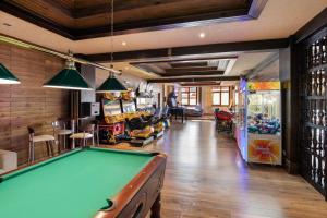 a billiard room with a pool table and a arcade at Melia Sierra Nevada in Sierra Nevada