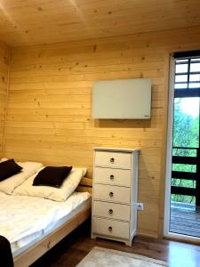sypialnia z łóżkiem i telewizorem na ścianie w obiekcie Sarzynówka pod Świerkiem w Krasnobrodzie