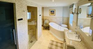 a bathroom with a tub and a sink and a bath tub at Crossbasket Castle in High Blantyre