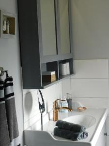a bathroom sink with a black cabinet above it at Ferienhaus-Steinburg in Steinburg +32 photos