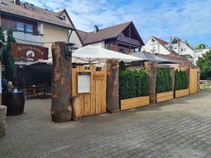 a wooden fence with an umbrella in front of a building at Gasthof Wolfs Stuben in Reichenbach an der Fils