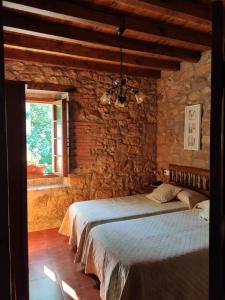 a bedroom with a bed in a stone wall at Apartamentos Rurales La Caviana in Cangas de Onís