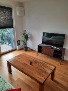 a living room with a wooden coffee table and a flat screen tv at Apartment vor Magdeburg in Gerwisch