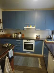 a kitchen with blue cabinets and a microwave at Merimaja in Hamina